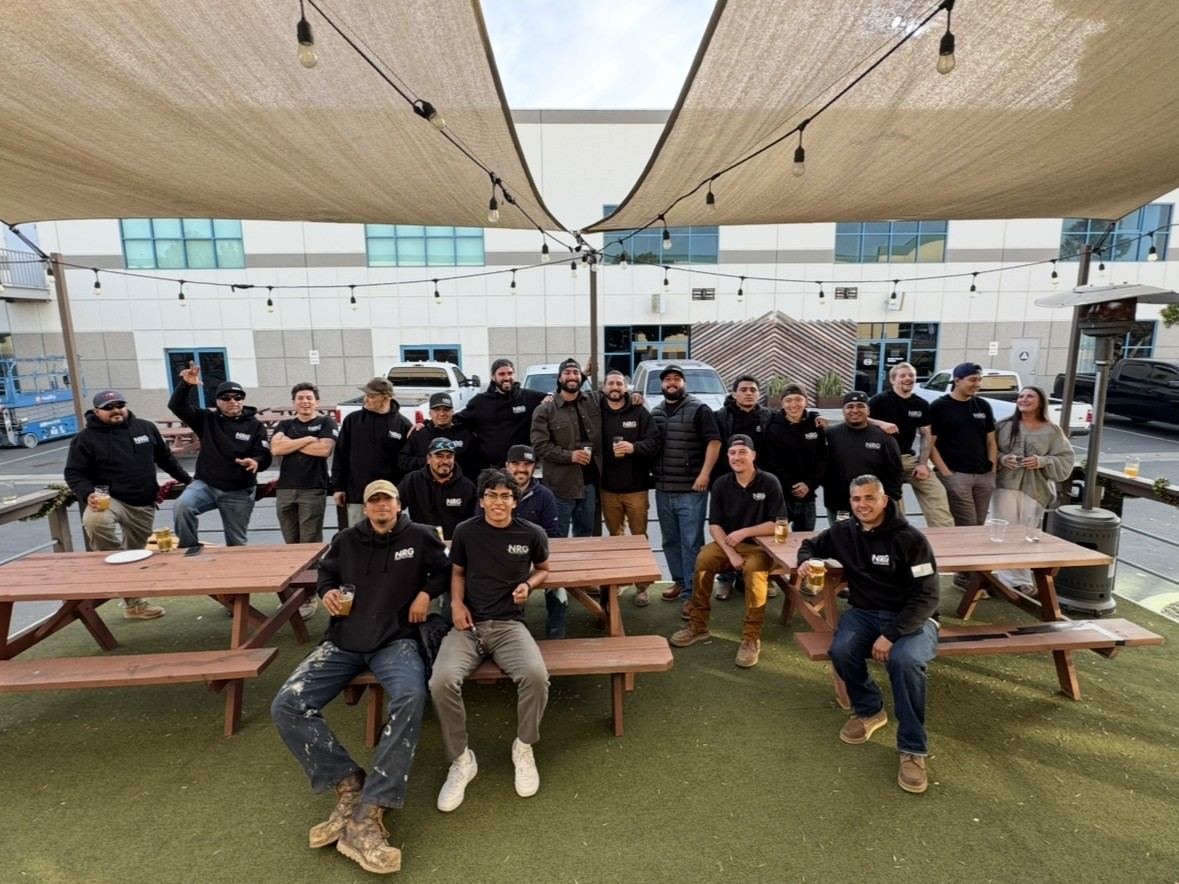 Crew team photo at picnic tables under the shade sails