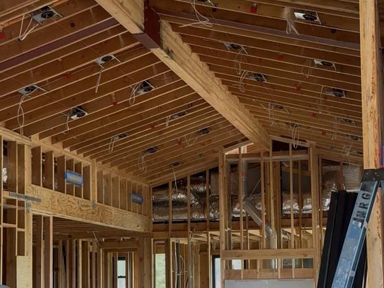 NRG Electric crew walking a vaulted custom-home frame during rough-in
