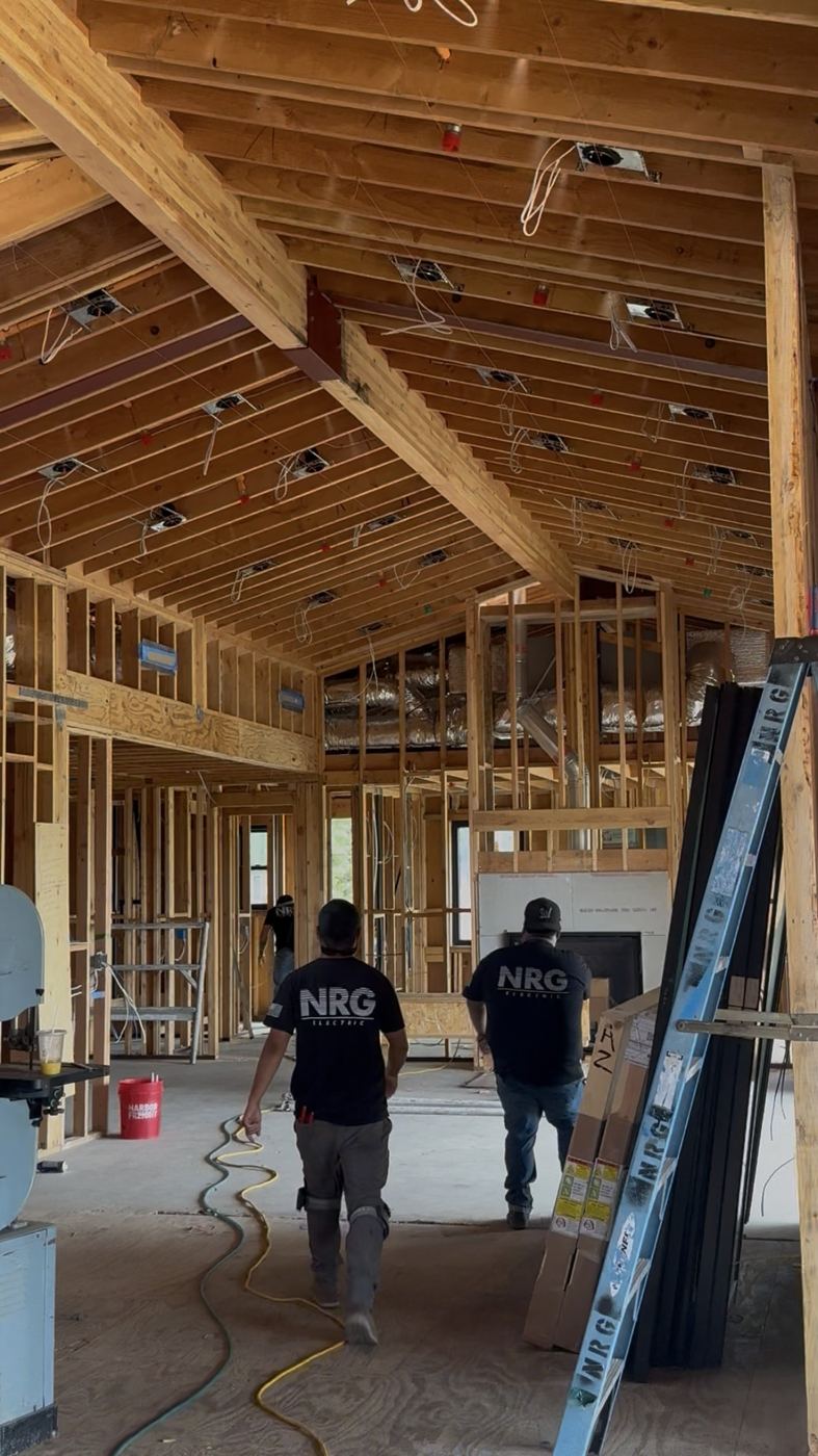 NRG Electric crew walking a vaulted custom-home frame during rough-in