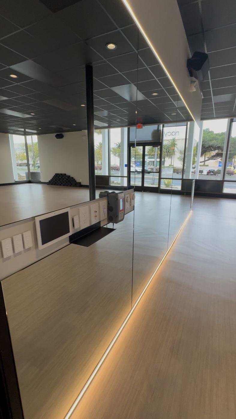 Mirror-walled studio room with perimeter LED floor glow